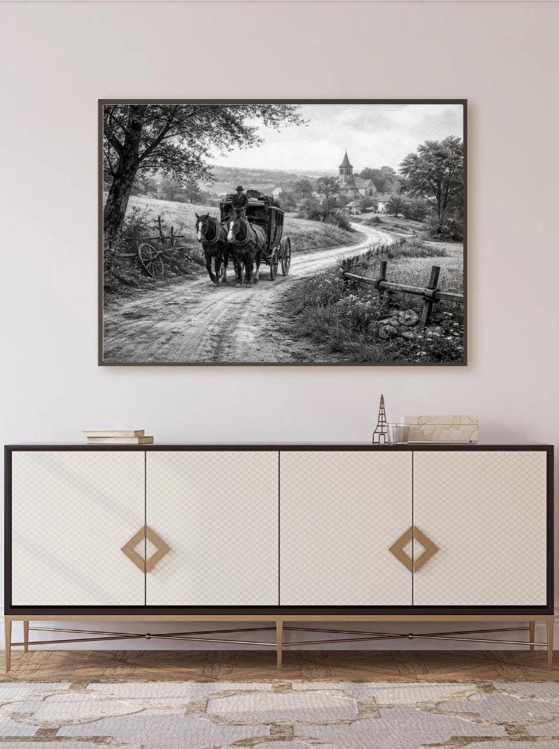 Peut inclure: Impression en noir et blanc d'une calèche tirée par des chevaux sur une route de campagne, menant à un village avec une église. L'œuvre est encadrée au-dessus d'un meuble blanc avec des détails dorés.